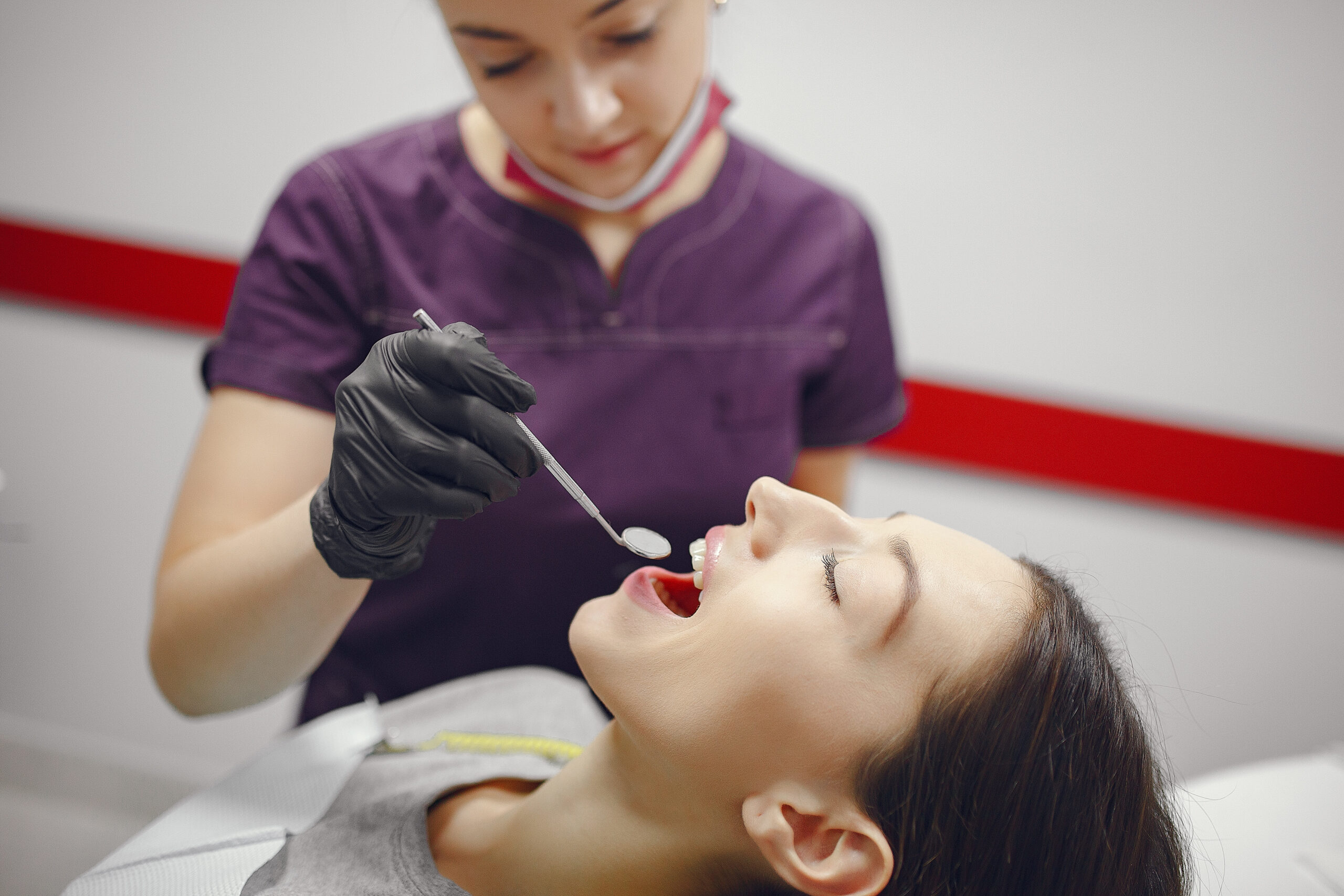 Beautiful lady in the dentist's office. Woman in a purple uniform