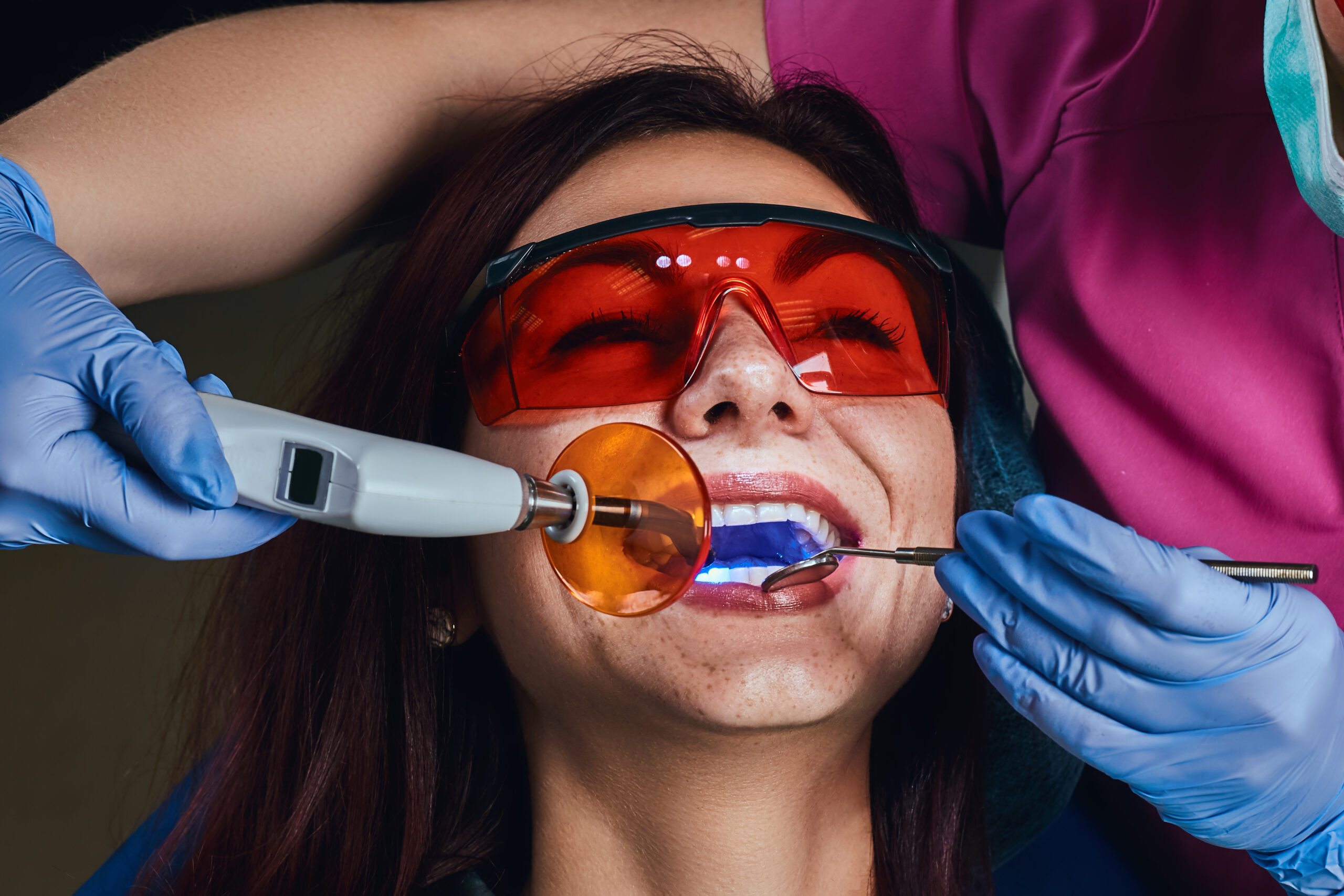 Female dentist treating a patient. Close-up photo of a young woman sitting in the dentist's chair.